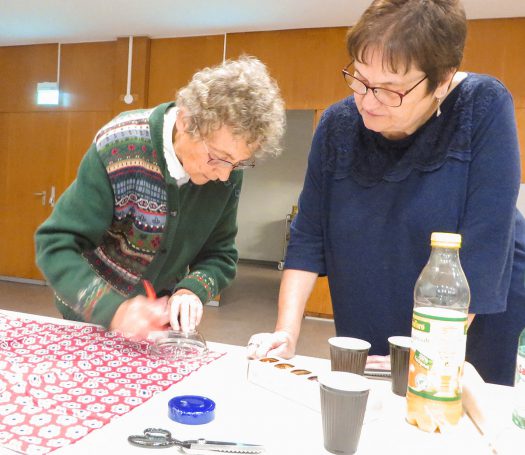 Kathi Fink (rechts) schaut Ingrid Bosch beim Zuschneiden der Deckchen zu