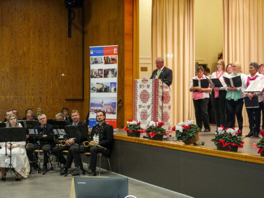 Ovidiu Cretu spricht ein Grußwort, links das Blasorchester Siebenbürgen-Drabenderhöhe, rechts der Honterus-Chor. Foto: Günther Melzer