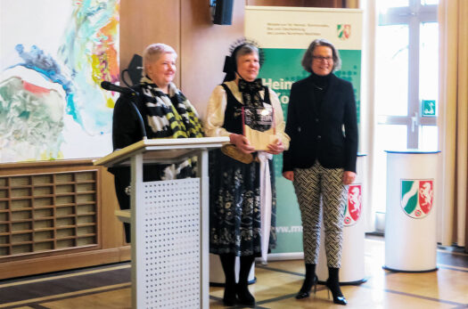 Ulrike Howath (Mitte) nahm die Auszeichnung aus der Hand von Ministerin Ina Scharrenbach (rechts) entgegen. Heike Mai-Lehni (links) gratulierte als Kulturreferentin und hielt die Laudatio 